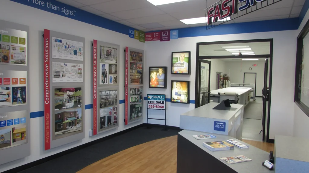 Interior of a FASTSIGNS center with display materials and service counter.